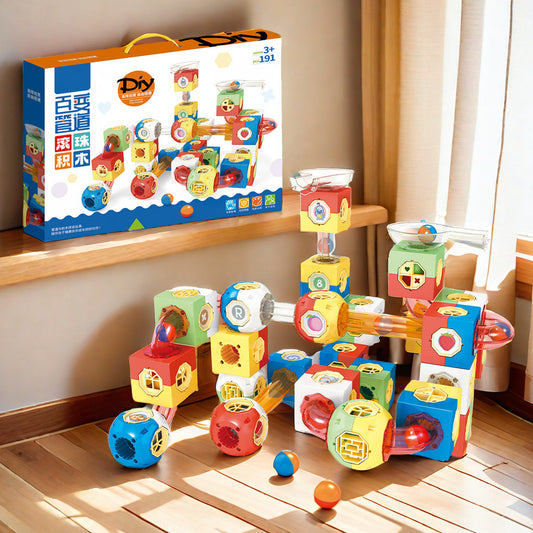 Kinder spielen mit einem magnetischen Murmelbahn-Set und bauen bunte Rohrleitungen und Tunnel