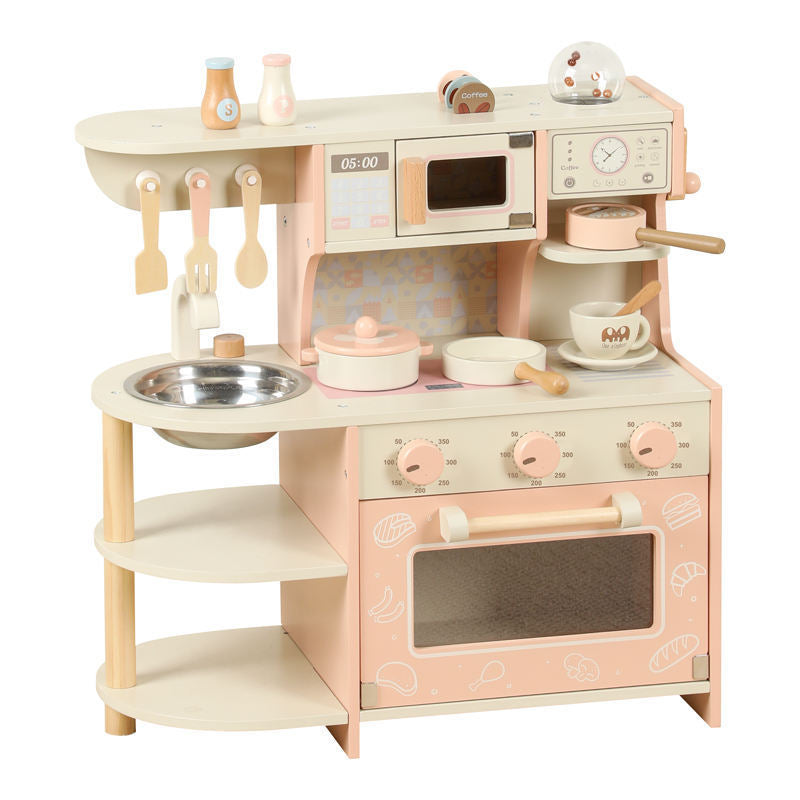Little Chef's Dreamland pink wooden toy kitchen set for kids, featuring a sink, stove, microwave, and storage shelf.