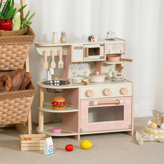 Little Chef's Dreamland pink wooden toy kitchen set for kids, featuring a sink, stove, microwave, and storage shelf.